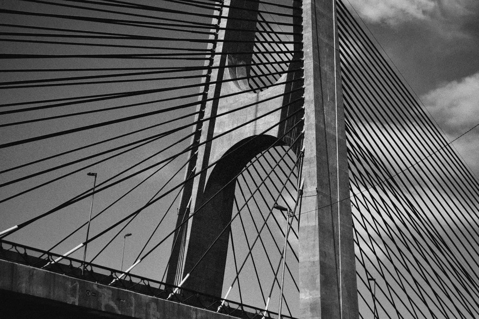 The pylon and cables of a cable-stayed bridge in black and white